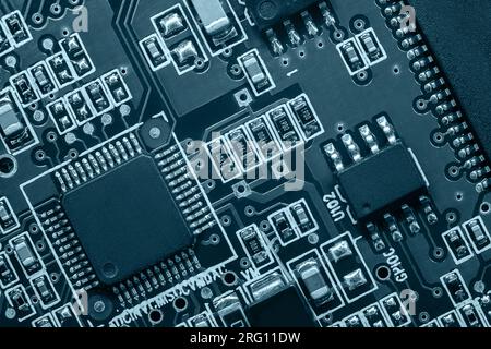 Closeup of Printed Circuit Board with processor, integrated circuits and many other surface mounted passive electrical components. Stock Photo