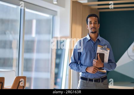 Young African American business man standing in office, portrait. Stock Photo