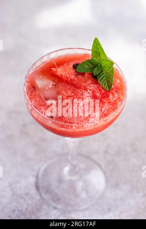 Top view of cup of fresh Margarita cocktail with watermelon smoothie covered with mint leaves Stock Photo