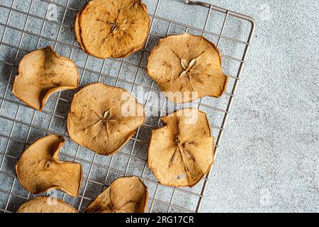 Top view of slices of dried apples on oven tray against blurred gray background Stock Photo