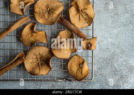 Top view of slices of dried apples on oven tray against blurred gray background Stock Photo