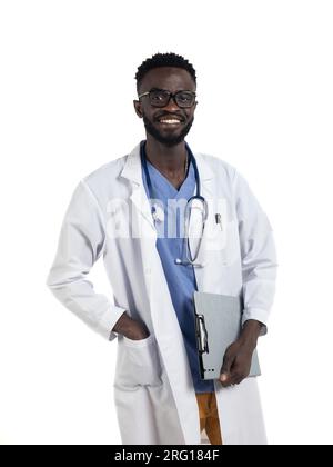 Smiling young African American male in eyeglasses stethoscope and uniform looking at camera while standing with hand in pocket carrying clipboard and Stock Photo