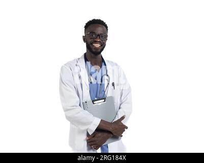 Smiling young African American male in eyeglasses stethoscope and uniform looking at camera while standing with arms crossed holding clipboard and iso Stock Photo