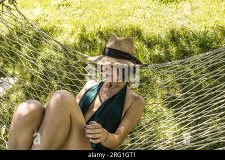 Woman on a lounger in the garden sunbathing Stock Photo