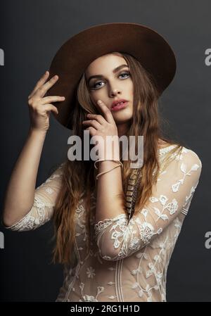 Fashion portrait of young beautiful woman wearing hat and white blouse Stock Photo