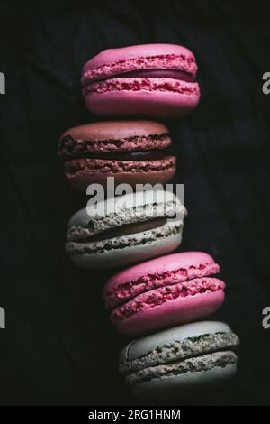 Macaroons on dark background, colorful french cookies macaroons. Macaroons in a row. Top view. Close-up. High quality photo. Stock Photo
