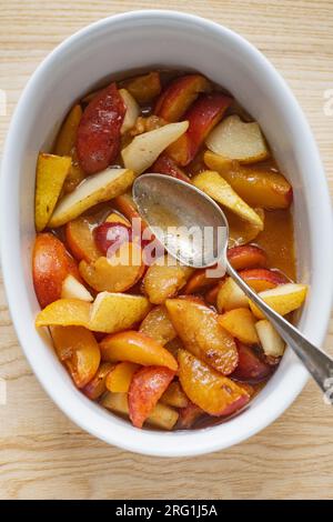 Sliced plums wih sugar and spices prepared in a baking form Stock Photo