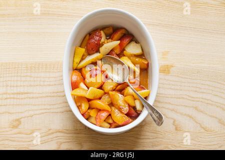 Sliced plums wih sugar and spices prepared in a baking form Stock Photo