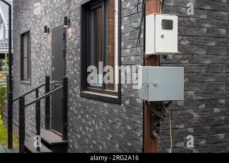 electrical panel on a pole in the backyard of the house. A switchboard can be responsible for safely supplying electricity to an apartment, floor, or Stock Photo