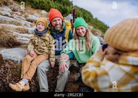 Little girl taking pictures of her family during a hike. Stock Photo