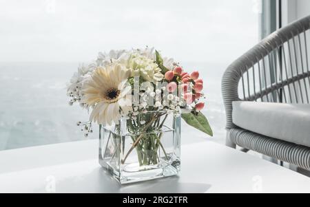 Beautiful white bouquet of flowers in vase on table of cruise ship. Stock Photo