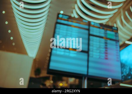 Departure board at airport, abstract out of focus background Stock Photo
