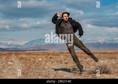 Man jumping on mountains background, Kyrgyzstan Stock Photo