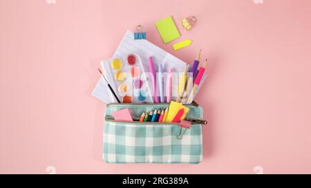 Stylish stationery for school and office in a pencil case on a pink background.  Stock Photo