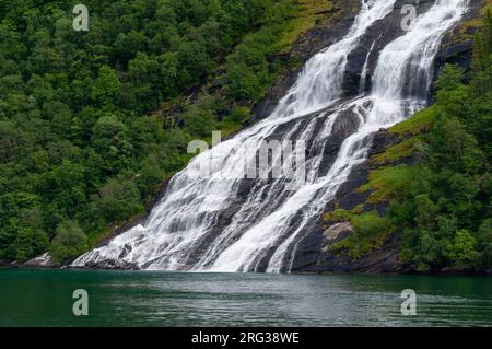 Seven Sisters waterfalls plunges off sheer cliffs into Geirangerfjord. Geirangerfjord, Norway. Stock Photo