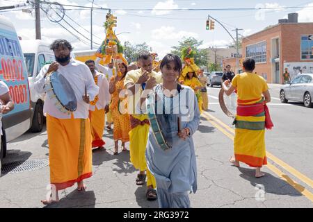 devout Hindus march, many barefooted, from their temple to the site of their walk on hot coals, On 101 Ave in Ozone Park Queens. Stock Photo