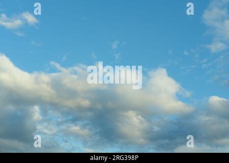 Blue sky background with white fluffy cumulus clouds. Panorama of white fluffy clouds in the blue sky. Beautiful vast blue sky with amazing scattered Stock Photo