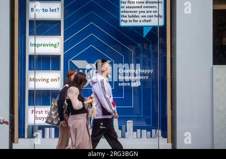 London, England, UK. 7th Aug, 2023. People are seen passing by a Halifax bank branch front window dedicated to housing products as increasing interest rates effect mortgage payments in the UK. (Credit Image: © Tayfun Salci/ZUMA Press Wire) EDITORIAL USAGE ONLY! Not for Commercial USAGE! Stock Photo