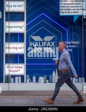 London, England, UK. 7th Aug, 2023. People are seen passing by a Halifax bank branch front window dedicated to housing products as increasing interest rates effect mortgage payments in the UK. (Credit Image: © Tayfun Salci/ZUMA Press Wire) EDITORIAL USAGE ONLY! Not for Commercial USAGE! Stock Photo