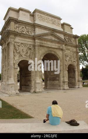 Triumphal Arch of Orange with a single man sitting and relaxing in front Stock Photo