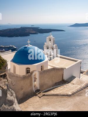 Three Bells of Fira - Blue-domed church and belfry with sea view, Assumption of Blessed Virgin Mary Catholic Church, Firostefani, Santorini, Greece Stock Photo