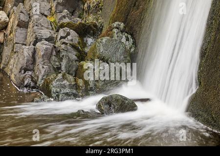 A waterfall crashes down a vertical cliff, on the coast at Speke's Mill Mouth, near Hartland Quay, the Atlantic coast of Devon, Great Britain. Stock Photo