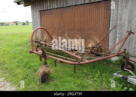 an old rusted historic hay tedder Stock Photo