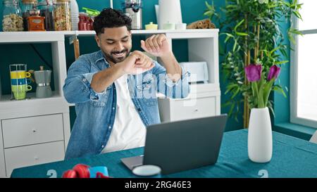 African american man using laptop sitting on table dancing at dinning room Stock Photo