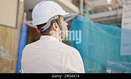 Young hispanic man architect talking on smartphone at street Stock Photo