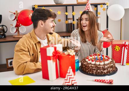 Mand and woman couple having birthday celebration kissing at home Stock