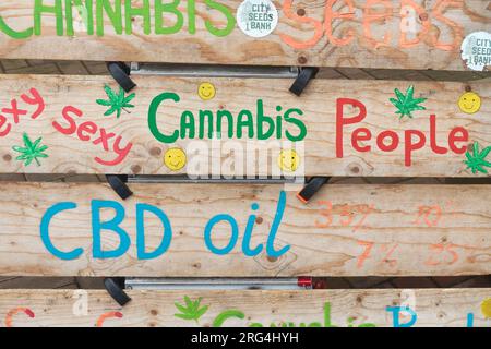 Amsterdam, The Netherlands - August 1, 2023: Painted text on wooden boards in front of a market stall selling cbd oil and cannabis products in Amsterd Stock Photo