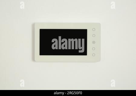 Modern video intercom hanging on white wall Stock Photo