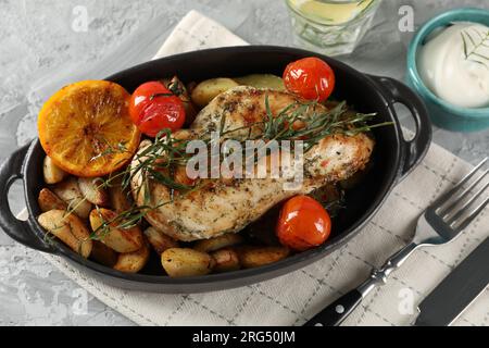 Tasty chicken, vegetables, drink with tarragon and sour cream served on grey table, flat lay Stock Photo