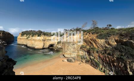 823 Western cliffs frame the beach at the bottom of Loch Ard Gorge, seen from Shipwreck Walk. Port Campbell NP-Australia. Stock Photo