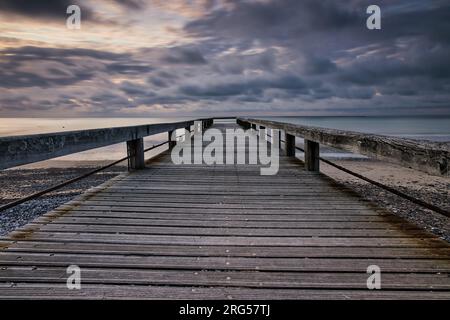 Wooden pier on cloudy sunset Stock Photo