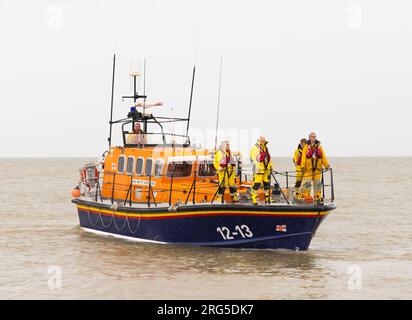 The Lifeboat crew standing on the bow of the Aldeburgh Lifeboat whilst at sea. Aldeburgh, Suffolk. UK. Stock Photo