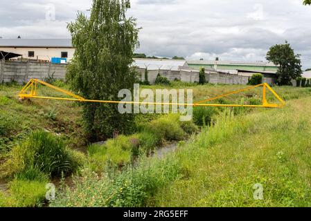 Natural Gas Pipeline Across the creek Stock Photo