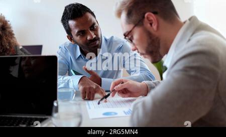 Multiethnic business people working at bank office analyzing data - Entrepreneur financial concept - Focus on Indian man face Stock Photo