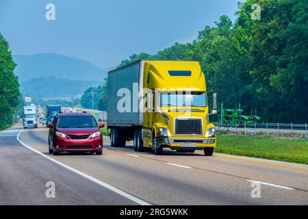 Horizontal shot of a yellow tractor trailer traveling on a Tennessee interstate highway. Stock Photo