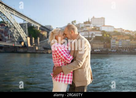 Loving Senior Spouses Embracing During Outdoor Walk On Promenade Stock Photo
