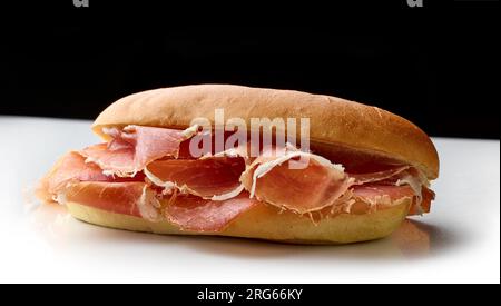 sandwich with sliced spanish iberico ham isolated on black and white background Stock Photo