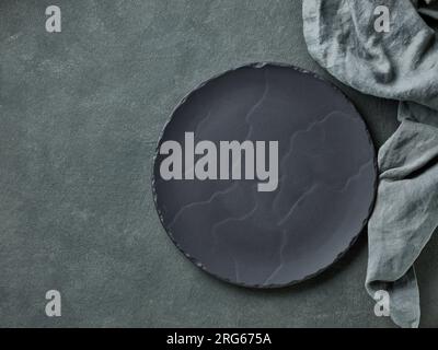 empty black plate on dark grey background, top view Stock Photo