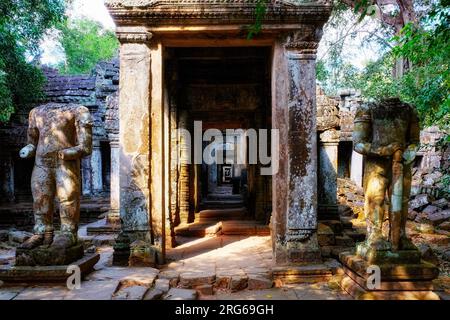 Weathered guardians: Two ancient damaged sculptures near Preah Khan's medieval Buddhist temple entrance. Stock Photo