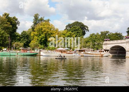 Colourful boats moored next to Kingston Bridge and the River Thames, Kingston-Upon-Thames, Surrey, England, U.K. Stock Photo