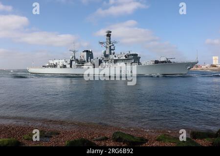 The Royal Navy frigate HMS IRON DUKE seen close to the shore as it passes through the harbour entrance Stock Photo