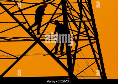 engineer working at tower, engineer working at power station, hight voltage tower Stock Photo