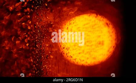 Background of blurred raindrops on glass at night in orange light. Abstract blurred background Stock Photo