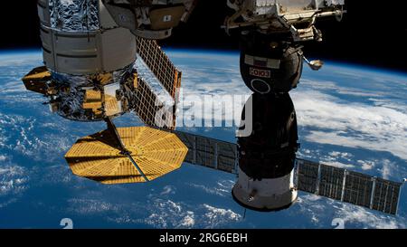 A U.S. and a Russian spacecraft are docked to the International Space Station as it orbits above the Pacific Ocean. Stock Photo