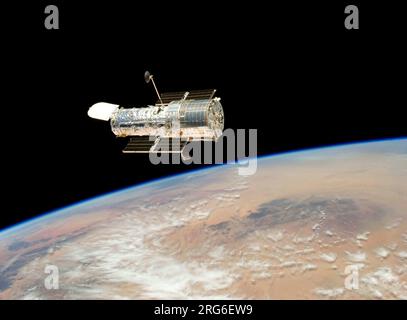 The Hubble Space Telescope drifts over planet Earth. Stock Photo