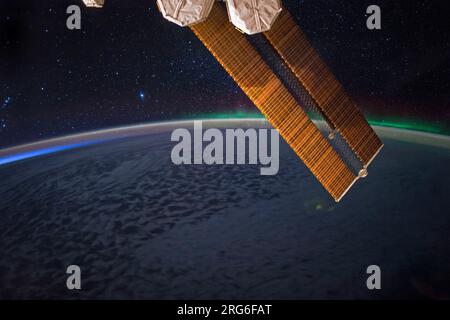 A glowing aurora australis, while passing over the Great Australian Bight and the cloud-covered Indian Ocean. Stock Photo